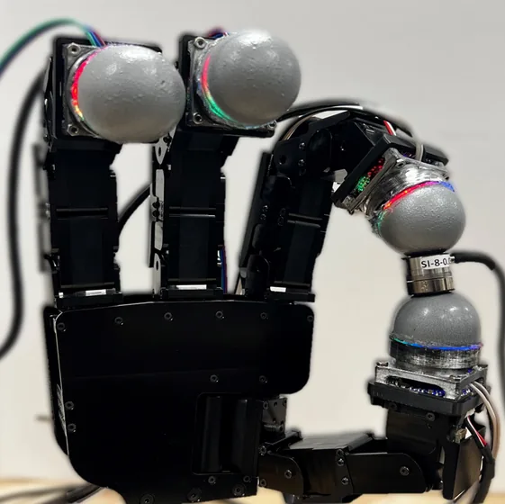 A robotic gripper fitted with dome-shaped optical tactile fingertips