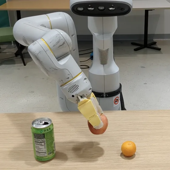 A mobile manipulator lifting an apple from a table beside a drink can and an orange