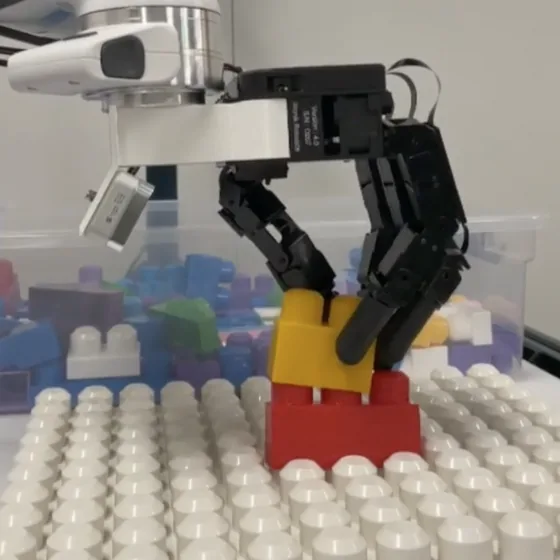A robot hand assembling toy building blocks